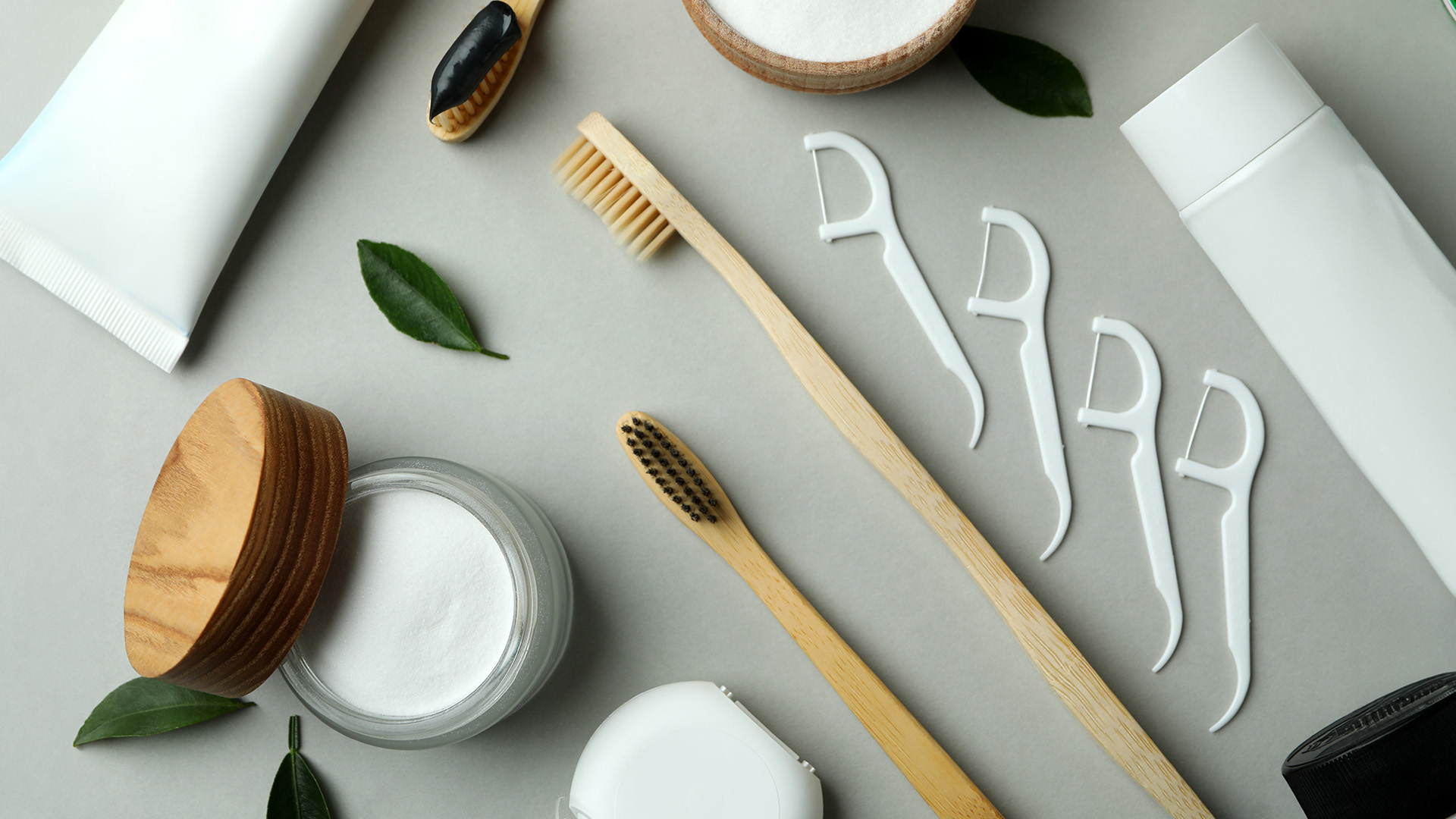 The image displays a collection of skincare products and tools arranged on a light-colored surface, with a focus on items related to facial care, including toothbrushes, face masks, and other personal hygiene items presented in an aesthetically pleasing manner.