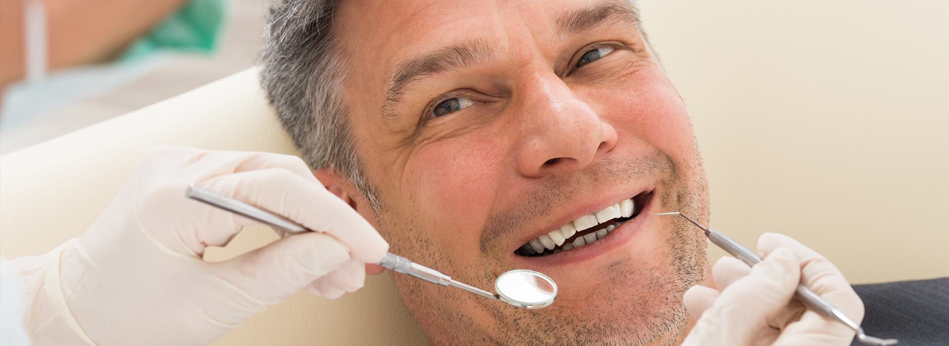 A man receiving dental treatment with a dentist working on his teeth.