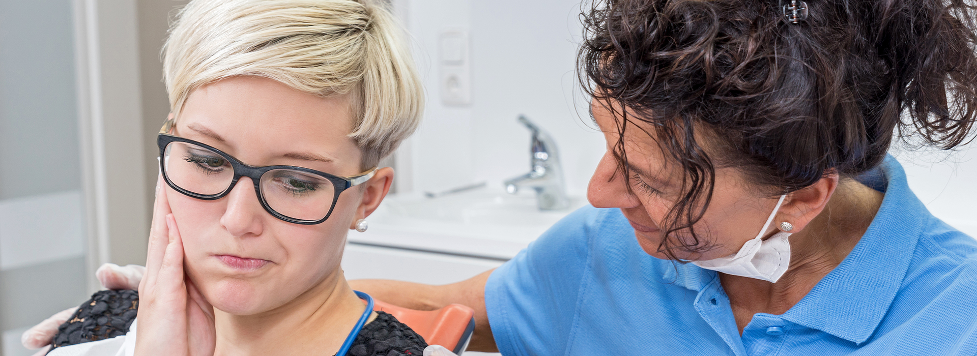 Woman receiving dental care with dental hygienist.