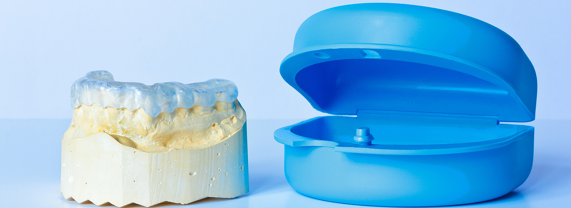 An alt text description for this image could be   A photograph displaying two dental molds side by side, with one mold showing a yellow substance inside.