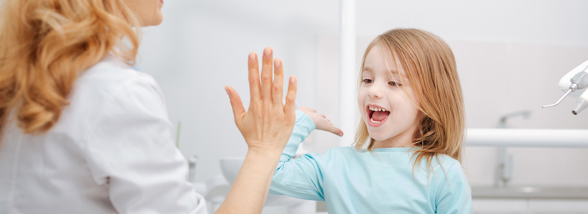 A woman and child interacting with each other in a bathroom setting.