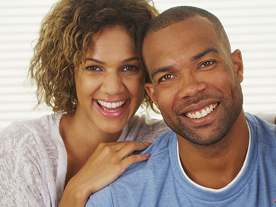 The image features a man and a woman posing together with smiles  they appear to be a couple sharing a happy moment.